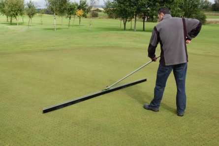 dew brush in use on golf course